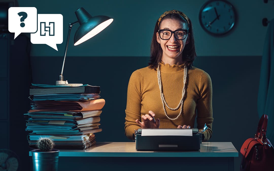 Woman Sitting at a Desk with Stack of Papers Next to her and Lamp On Top | Hurrdat Answers Post